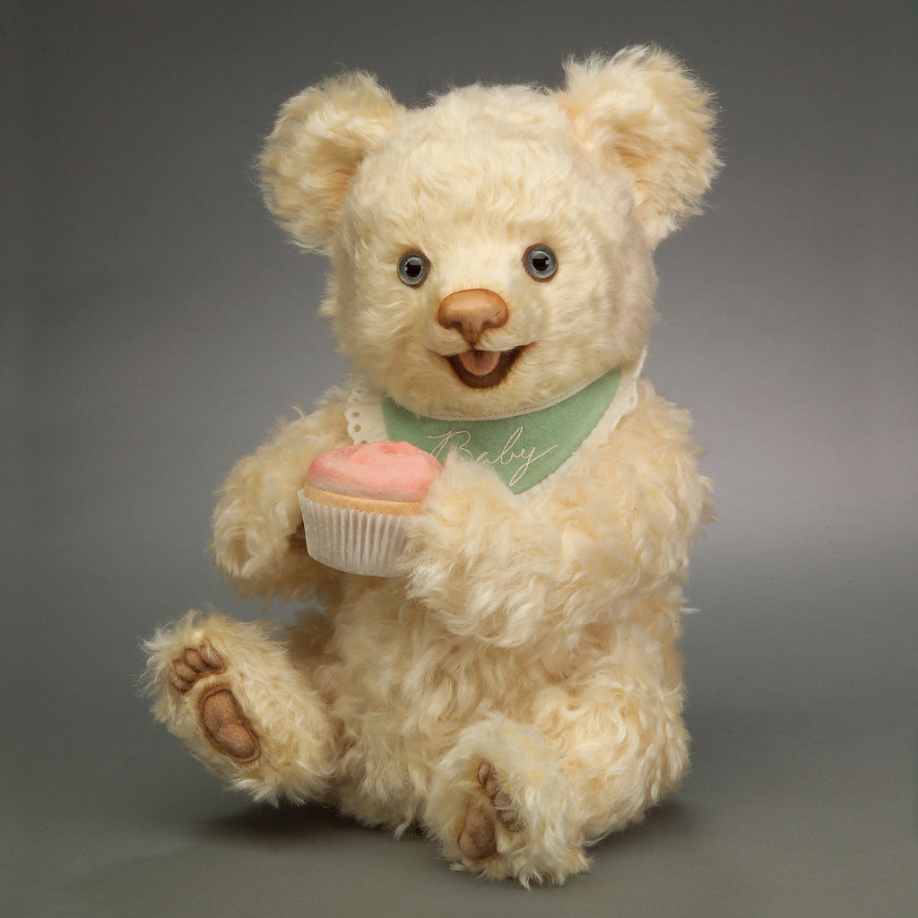 a teddy bear with a molded felt cupcake